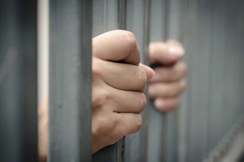 Hands Behind Jail Bars Needing Bail Bonds in Pasadena, TX