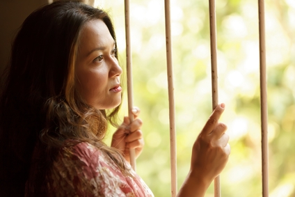 Worried woman behind bars needing traffic bail bonds in Houston Gardens