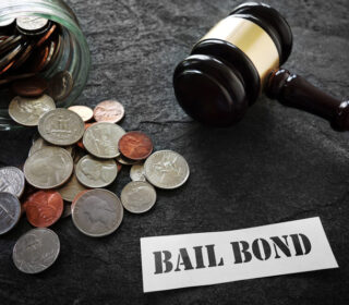 Gavel and coins with a bail bond sign for cheap bail bonds in Madisonville