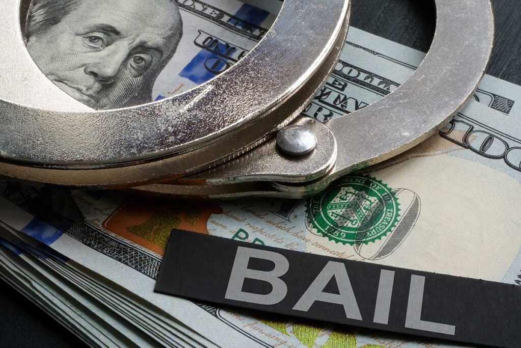Handcuffs on cash with a bail sign for cheap bail bonds in Second Ward