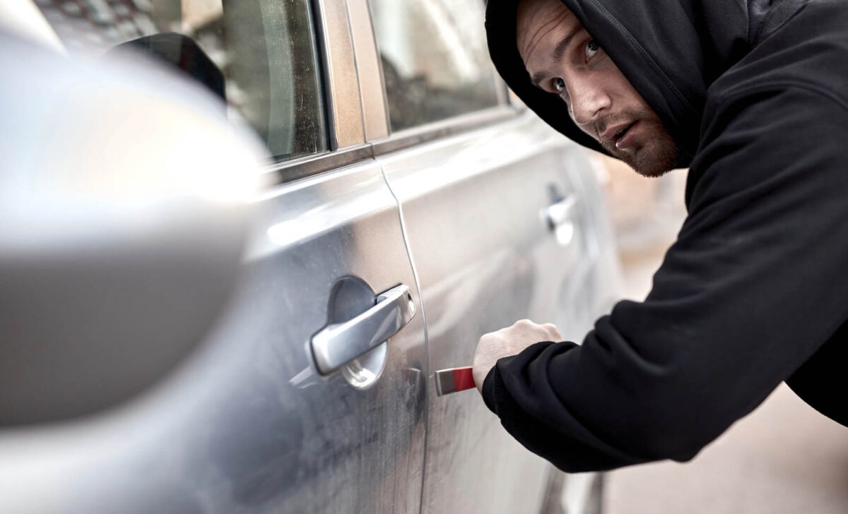 Auto theft suspect breaking into a car before needing felony bail bonds in Tomball